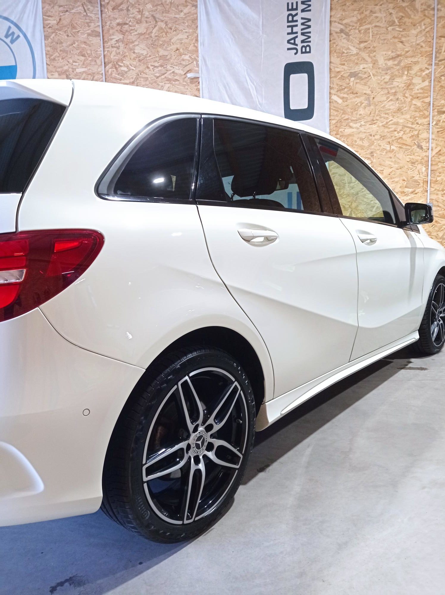 Voiture de luxe blanche nettoyée et lustrée par Ecomobile présentée dans un showroom, mettant en valeur son éclat et sa finition soignée